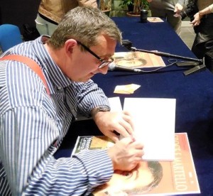 Vito durante la conferenza stampa autografa il suo libro ai tanti fans
